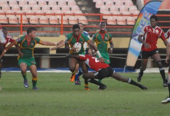 National rugby player Claudius Butts (with ball) on the attack during Guyana’s 20-nil mauling of Trinidad and Tobago’s Calypso Warriors yesterday at the Providence National Stadium in the Southern Zone of the NACRA Regional Qualifiers for the 2015 Rugby World Cup. (Orlando Charles photo)
