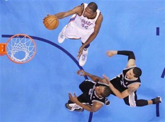 Oklahoma City Thunder forward Kevin Durant (35) scores past San Antonio Spurs forward Kawhi Leonard (2) and guard Daniel Green (4) in the second half during Game 3 of the NBA Western Conference basketball finals in Oklahoma City, Oklahoma. Reuters/Steve Sisney