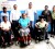 Simone Poole (seated, center) and Stacy Johnson (seated, right) in their new electronic chairs, as officials of Food for the Poor, the National Commission on Disability and the Health Ministry look on.