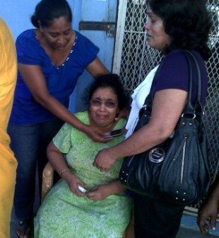Proprietress of Indra's Indra Shiwprasad (centre) being comforted yesterday. Her husband Ramdat died of a heart attack after the fire started.