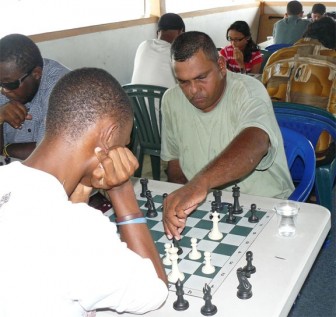 Former national chess champion Kriskal Persaud makes a move against Anthony Drayton during Sunday’s fifth round of the inaugural Red Cherry tournament at the Kei-Shar’s Sports Club.

