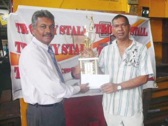 Ramesh Sunich, Managing Director, Trophy Stall hands over the sponsorship cheque to Ramesh Seebarran, left president of the Guyana Tennis Association.