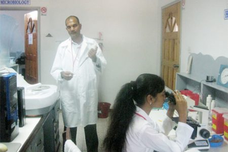 Rohan Sookdeo and his assistant in the medical laboratory