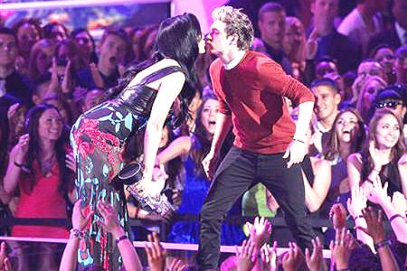 Presenter Katy Perry leans in to kiss One Direction’s Niall Horan as the band accepts the award for best pop video for their song ‘’What Makes You Beautiful’‘ during the 2012 MTV Video Music Awards in Los Angeles, September 6, 2012. (Reuters/Mario Anzuoni)
