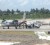 The two suspects (first and second left) about to enter the police vehicle on the airstrip.
