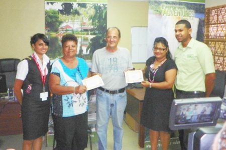 Frank Willison (centre) presents winning certificates to Jennifer Chu-A-Kong (second left) and Shaleni Nauth (second right) while Correia Group representatives look on.