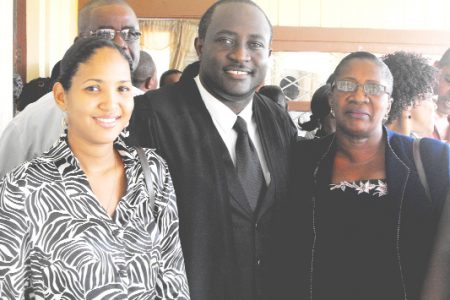 New addition: Jacy Archibald (centre) with his mother Ercellen Cummings-Archibald (right), his wife Roxanda (left) and his father, James Archibald (in background) after he was admitted to the bar at the High Court yesterday.
