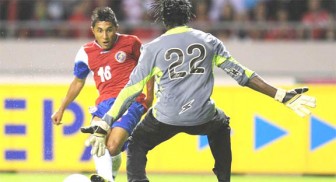 Costa Rica’s Allen Guevara slips the ball past the outstretched hands of Guyana’s goalkeeper Derrick Carter. (Photo courtesy of FIFA.com)