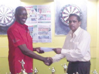 One of the sponsors of the tournament presents a cheque to Darts Association president Grantley Culbard (left). (Photo by Treiston Joseph)
