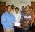 Dwayne John, (left) Civil Engineer hands over the cheque to  a representative of the GDF football team