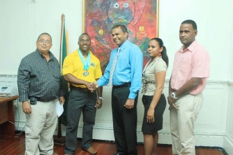  Dr. Frank Anthony congratulates World Power lifting dead lift champion Randolph Morgan in the presence of Peter Green, Lynette Lewis, executive member of the Guyana Amateur Power Lifting Federation and national coach Denroy Livan.