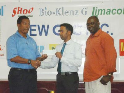 Marketing Manager of the New Guyana Pharmaceutical Company, Trevor Bassoo, hands over the cheque to Co-Director of the Kashif and Shanghai Organisation Kashif Muhammad in the presence Aubrey `Shanghai’ Major.