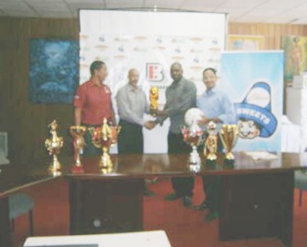Organiser of the Chico Kashif and Shanghai Junior Football Tournament  Aubrey ‘Shanghai’ Major (second from right), receives the cheque from Vice Chairman of the Edward B. Beharry and Company, Suresh Beharry, while Chairman Anand Beharry (right) and co-organiser Kashif Muhammad look on.
