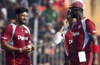 Darren Sammy (right) discusses strategy with fast bowler Ravi Rampaul (left). Lendl Simmons (partially hidden) looks on. (Photo courtesy WICB) 