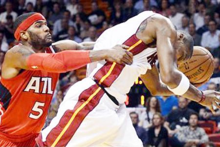 Miami Heat’s Chris Bosh (R) is fouled by Atlanta Hawks’ Josh Smith (L) during the first half of their NBA basketball game in Miami, Florida, December 10, 2012.
REUTERS/Rhona Wise
