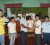 Hifeng Sue, flanked by teammates, accepts the team trophy from vice-president of the Guyana Chess Federation, Irshad Mohammed.
