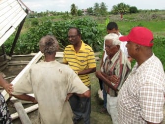 Minister of Local Government and Regional Development Ganga Persaud speaking with a family affected by high winds in Wash Clothes, Mahaicony (GINA photo)