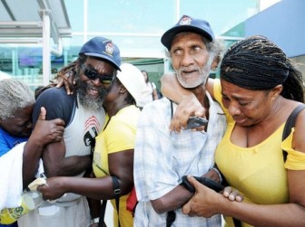 Everton Gregory (second left) and John Sobah (second right) are hugged by family and friends after they returned to Jamaica following an almost month-long ordeal. (Jamaica Gleaner photo)