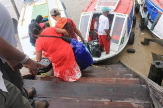 Passengers descending the slippery, deteriorating stairs to board the boats.