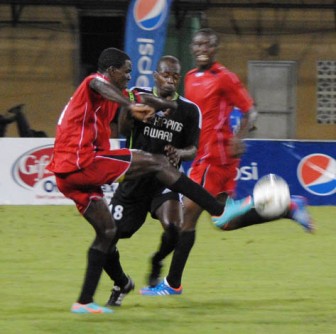 Buxton United MVP Dwain Jacobs (left) tussling with an opponent from Amelia’s Ward United in the finals of the K&S football tourney held at the National Stadium on New Year’s Day. (Photo by Aubrey Crawford)