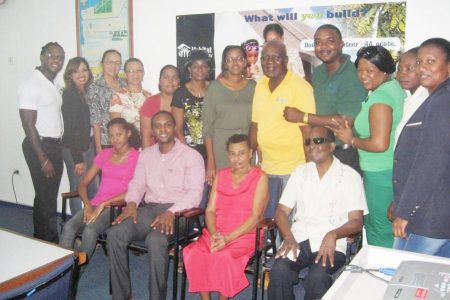 National Director, HfHG, Rawle Small (seated-second left); home owner, Kamanie Chichester (seated – third left), sponsors of the Buy-a-Block 2012 initiative; and HfHG staff. (Habitat photo)