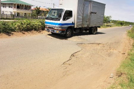 A truck trying to navigate its way through the Bee Hive main access road, East Coast Demerara.