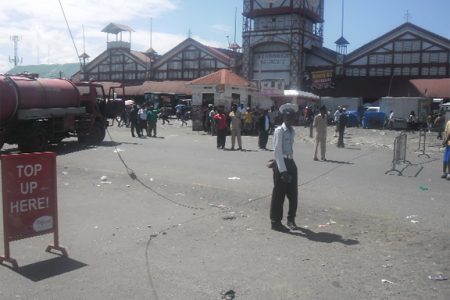 Policemen stand around the guy wire near Stabroek Square after it was disconnected from its power source. (Javone Vickerie photo)  See story on page 2