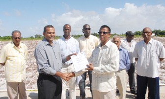 Minister of Sport, Dr. Frank Anthony yesterday awarding one of the sub lot contracts to a Bholonauth Contracting and Engineering Services repreasentative.

