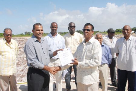 Minister of Sport, Dr. Frank Anthony yesterday awarding one of the sub lot contracts to a Bholonauth Contracting and Engineering Services repreasentative.
