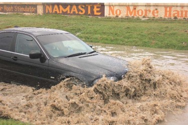  A brave driver taking the risk of driving along the flooded East Coast Demerara Road yesterday afternoon. (Photo by Arian Browne)
