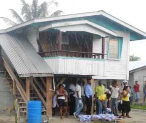 Police and relatives at the scene of the murder yesterday.