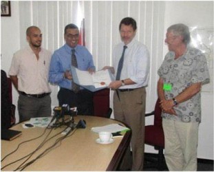 Minister of Natural Resources and the Environment Robert Persaud (second from left) and German Ambassador Stefan Schluter with the note signed. (GINA photo)