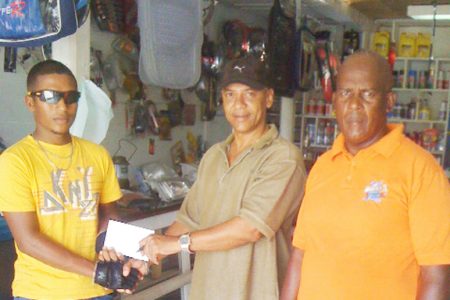 Sponsor and businessman Mark Lewis presenting the monetary donation to rider Neil Reece for his 2012 achievements as Coach Randolph Roberts looks on.
