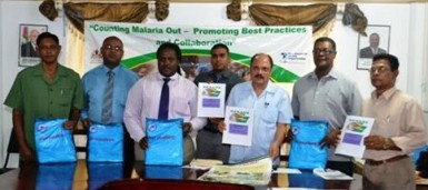 Minister of Health, Dr. Bheri Ramsaran (third from right) and representatives from the partnering organisations displaying the nets and accountability documents. (GINA photo)