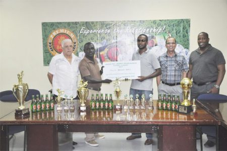 Organiser Marlon Washington in the presence of Banks DIH officials last Friday collects the sponsorship cheque from Premium Beer Brand Manager Jeoff Clement (third right). 