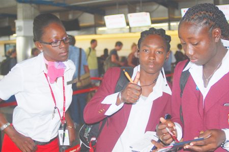 SHEMAINE CAMPBELLE GIVES THE THUMBS UP SIGN! Shemaine Campbelle gives the thumbs up sign as she and Stafanie Taylor get assistance from a Virgin Atlantic staffer as the West Indies women’s team departed the region on their way to India for the Women’s 2013 World  Cup competition which begins on Thursday. WICB Media Photo/Philip Spooner