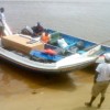 Searchers arrive with Ricky Bobb’s body yesterday morning shortly after it was recovered from the Mazaruni River.