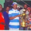 Travis Cameron, left of Mix Up dominoes team receives the trophy from a representative of the sponsor while Linden Boston of Boss Construction is third from right.