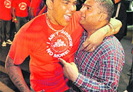 Newly-crowned Chutney Soca Monarch Raymond Ramnarine, left, celebrates with Attorney General Anand Ramlogan shortly after the results were announced at Skinner Park, San Fernando yesterday morning.
