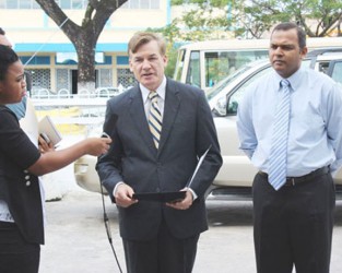 US Ambassador D Brent Hardt speaks at the presentation of the vehicle. At right is Culture, Youth and Sports Minister, Dr Frank Anthony. (US Embassy photo)