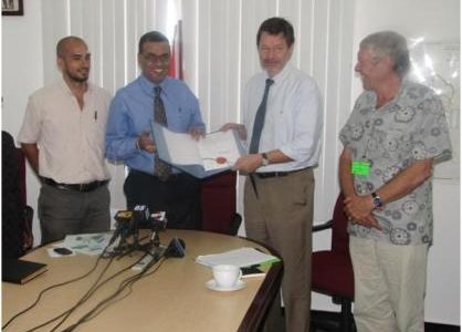 Minister of Natural Resources and the Environment Robert Persaud (second from left) and German Ambassador Stefan Schluter with the note signed. (GINA photo)