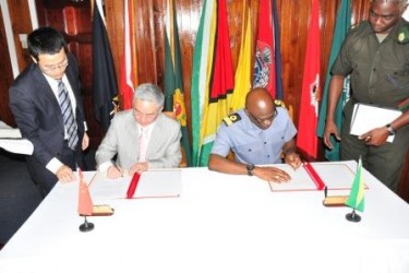In this GDF photo Ambassador Zhang Limin (second from left) and Commodore Gary Best sign the protocol.