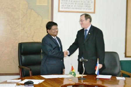 Finance Minister Dr Ashni Singh and Russian Ambassador to Guyana Mr Nikolay Smirnov shake hands after signing the debt write-off. (Government Information Agency Photo)