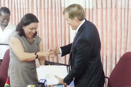 Guyana’s Foreign Minister Carolyn Rodrigues and US Ambassador Brent Hardt exchange copies of the agreements that will see Guyana getting help to go after drug lords along with training for key personnel. (Photo by Arian Browne)