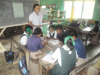 Headmistress of the Yupukari Primary School,  Maisie Li with her students 