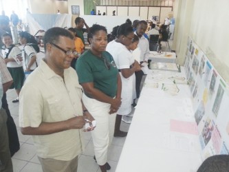 President of the Guyana Gold and Diamond Miners Association Patrick Harding takes notes from educational malaria information on display at Thursday’s National Malaria Conference.