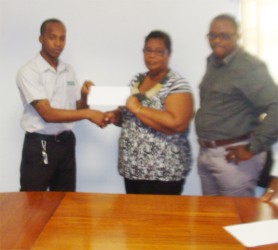 Quacy Coates of NCN hands over the sponsorship cheque on behalf of his company to Angela Haniff of the Berbice Cricket Board as NCN CEO Michael Gordon looks on. 