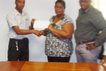 Quacy Coates of NCN hands over the sponsorship cheque on behalf of his company to Angela Haniff of the Berbice Cricket Board as NCN CEO Michael Gordon looks on.
