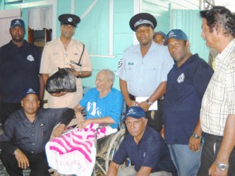 Joylall Beepat receiving a hamper from senior superintendant, Jairam Ramlakhan (second from left) in the presence of Nandkishore Deokie (stooping, at left) and others during the exercise.