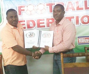 GFA’s treasure Dexter Schultz presenting the audited financial reports to acting GFF president Franklin Wilson (right). 